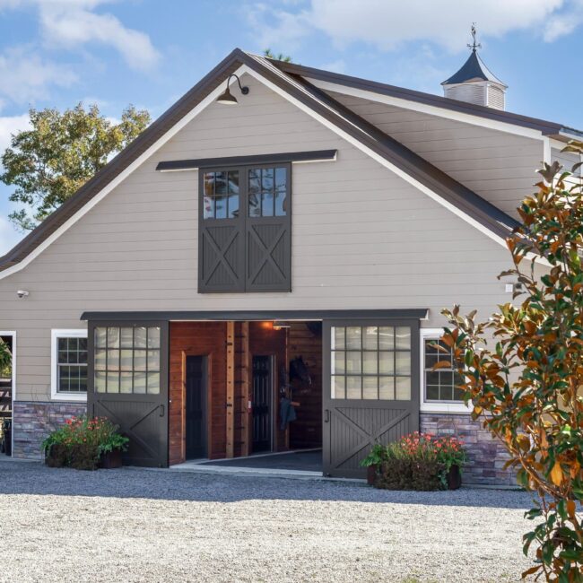 Beautiful barn with sliding barn doors and carriage windows, showcasing our customizable design options for finish and color.