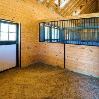 Barn interior with Dutch window and protective stall grill, featuring wood paneling and black metal finish options.