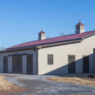 Modern barn with sliding carriage doors, awning windows, and Dutch doors. Customizable finishes and protective stall options.