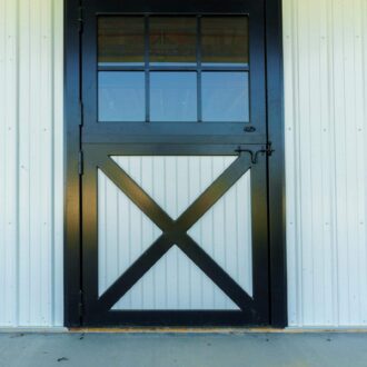 Black framed Dutch door with glass panels on white siding, featuring an X design. Standard finish options available.