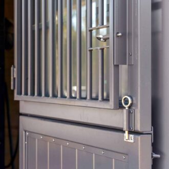 Metal Dutch door with protective grill, stainless finish. Ideal for barns, featuring secure latch and modern design.