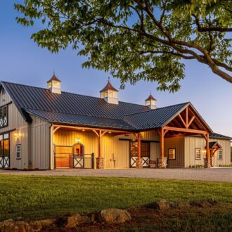 Elegant barn with sliding barn doors, Dutch doors, and Dutch windows; features a rustic finish.