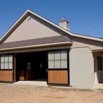 Modern barn with custom sliding barn doors and black frames, featuring wood finish and standard features.