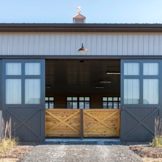 Modern barn with sliding barn doors. Features customizable finishes and entry door options.