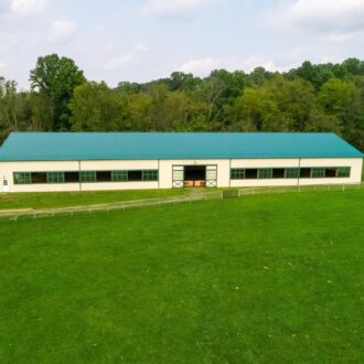 Aerial view of an arena, set against a green landscape.