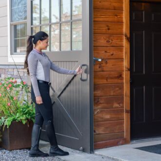 A woman sliding open an exterior barn door