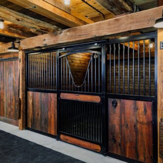 Rustic stall with sliding barn door, protective grill, and rich wood finish. Ideal for secure, stylish barn settings.