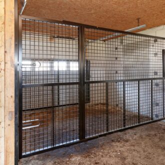 Mesh stall front with protective grills, ideal for barns. Features customizable finishes for enhanced durability.