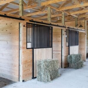 Sliding stall doors with full grills and solid wood inset, mounted on wood stall fronts.