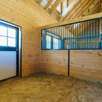 Stall with dutch door and protective grill in natural wood finish, featuring sliding windows and durable construction.