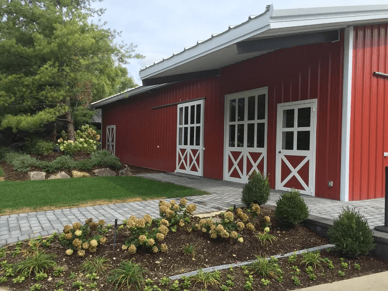 A sidewalk leading up to a horse barn