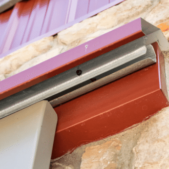 Close-up of sliding barn door track, metal finish, mounted on stone wall. Ideal for loft doors and carriage doors.