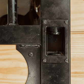 Close-up of a stall door featuring a button latch.