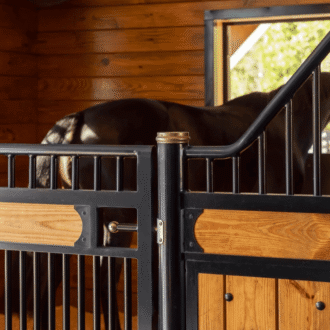 Stall door with spring pull latch. As shown, brass handle and black hardware on wood stall partitions and doors with black grills.