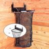 Black mesh haynet hay feeder on wooden wall with chain suspension. Ideal for barn use.
