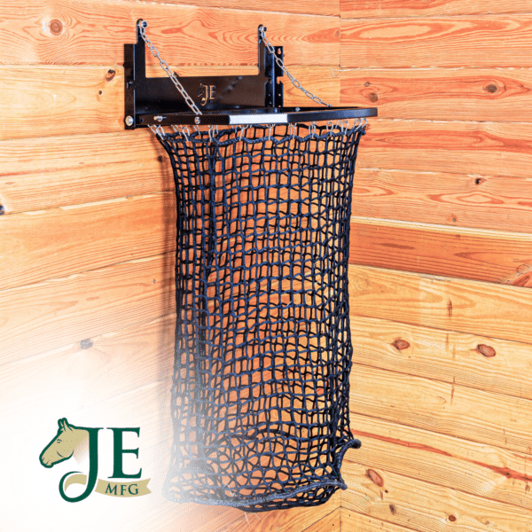 Black mesh haynet hay feeder on wooden wall with chain suspension. Ideal for barn use.