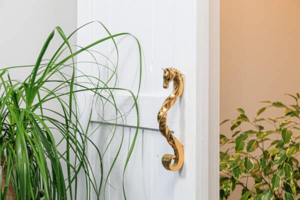 White entry door with gold horse head handle. Ideal for sliding barn doors.