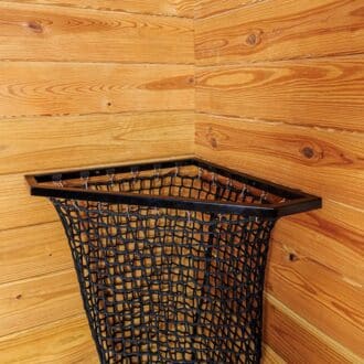 Corner EZ-fill haynet with black mesh in wood-paneled stall, designed for slow feed and efficient hay storage.