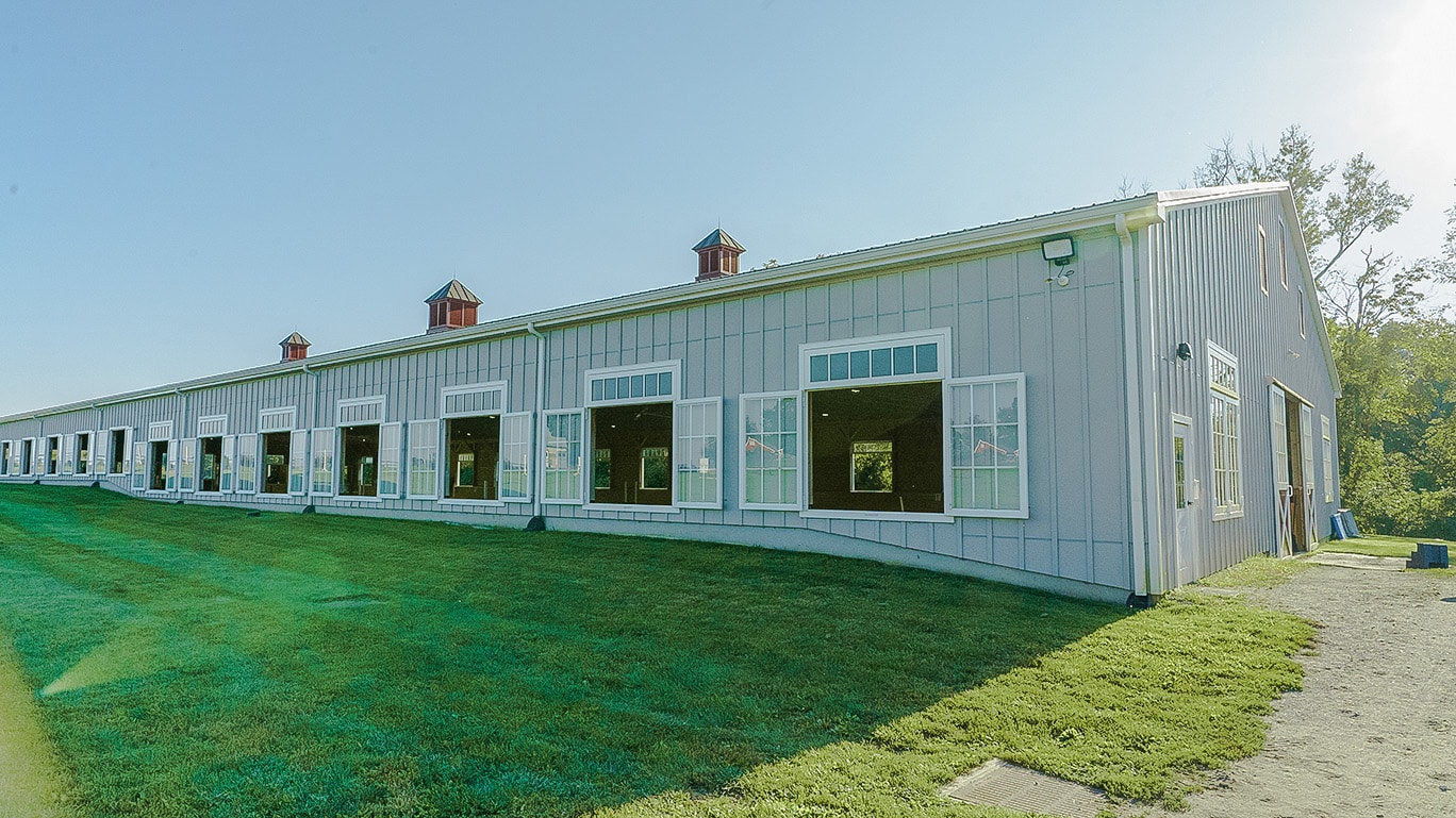 Image of a barn with sliding doors and arena windows for better lighting and ventilation