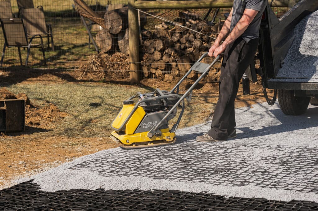 Tamping pea-gravel into mudX as part of the ground stabilization grid installation process